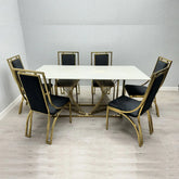 Amelia white ceramic dining table with gold Windsor chairs from Solid Furniture UK in a modern dining room