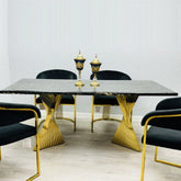 Black and gold Ravello 160cm marble-effect dining table with gold pedestal base, paired with elegant Porado dining chairs in a modern luxury dining room setting. solid furniture UK