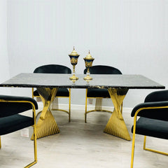 Black and gold Ravello 160cm marble-effect dining table with gold pedestal base, paired with elegant Porado dining chairs in a modern luxury dining room setting. solid furniture UK