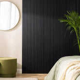 Bedroom interior in the UK featuring black HDF acoustic slatted wall panels 60x240cm by Solid Furniture UK, creating a modern and sound-controlled environment.