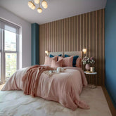 Dark oak multi-width acoustic wall panels installed in a modern living room feature wall creating a stylish and warm interior design solid furniture UK