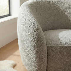 Nolita boucle accent chair side view showing curved backrest and cushioned seat | Solid Furniture UK