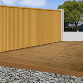 Oak WPC outdoor wall panels 180cm and 290cm installed in a modern UK garden setting by Solid Furniture LTD, showcasing natural wood-effect exterior wall design