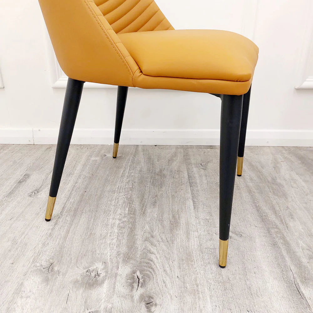 Close view of Alba Leather Dining Chair featuring black Scandinavian style legs with gold capped feet by Solid Furniture UK
