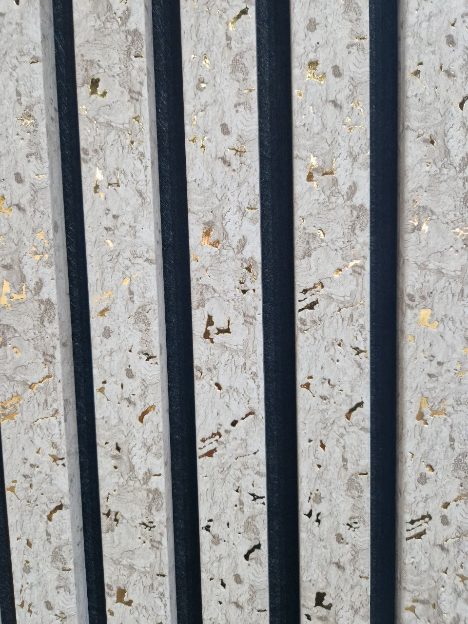 Beige acoustic wall panels with gold vein accents installed on a modern living room wall, designed for sound absorption and stylish interior décor solid furniture uk
