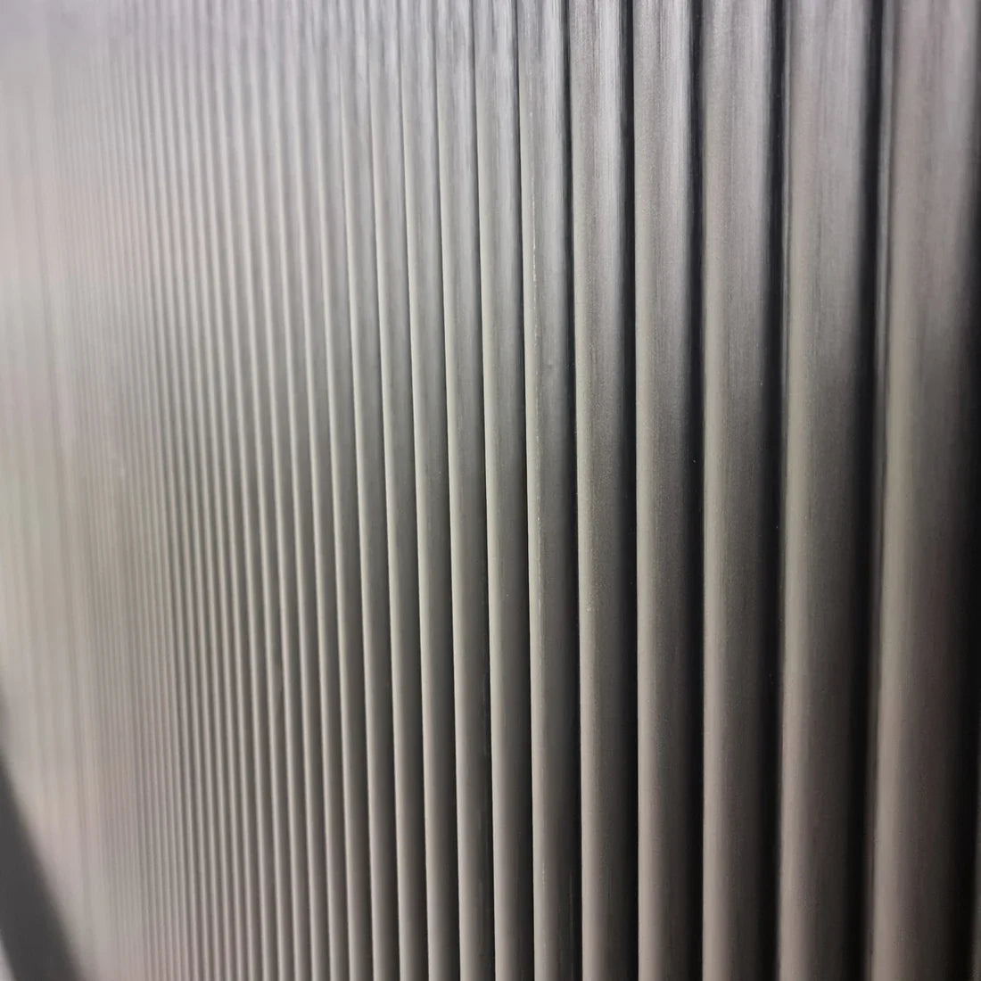 Side view of black fluted WPC wall panels by Solid Furniture UK showing the depth and vertical panel design