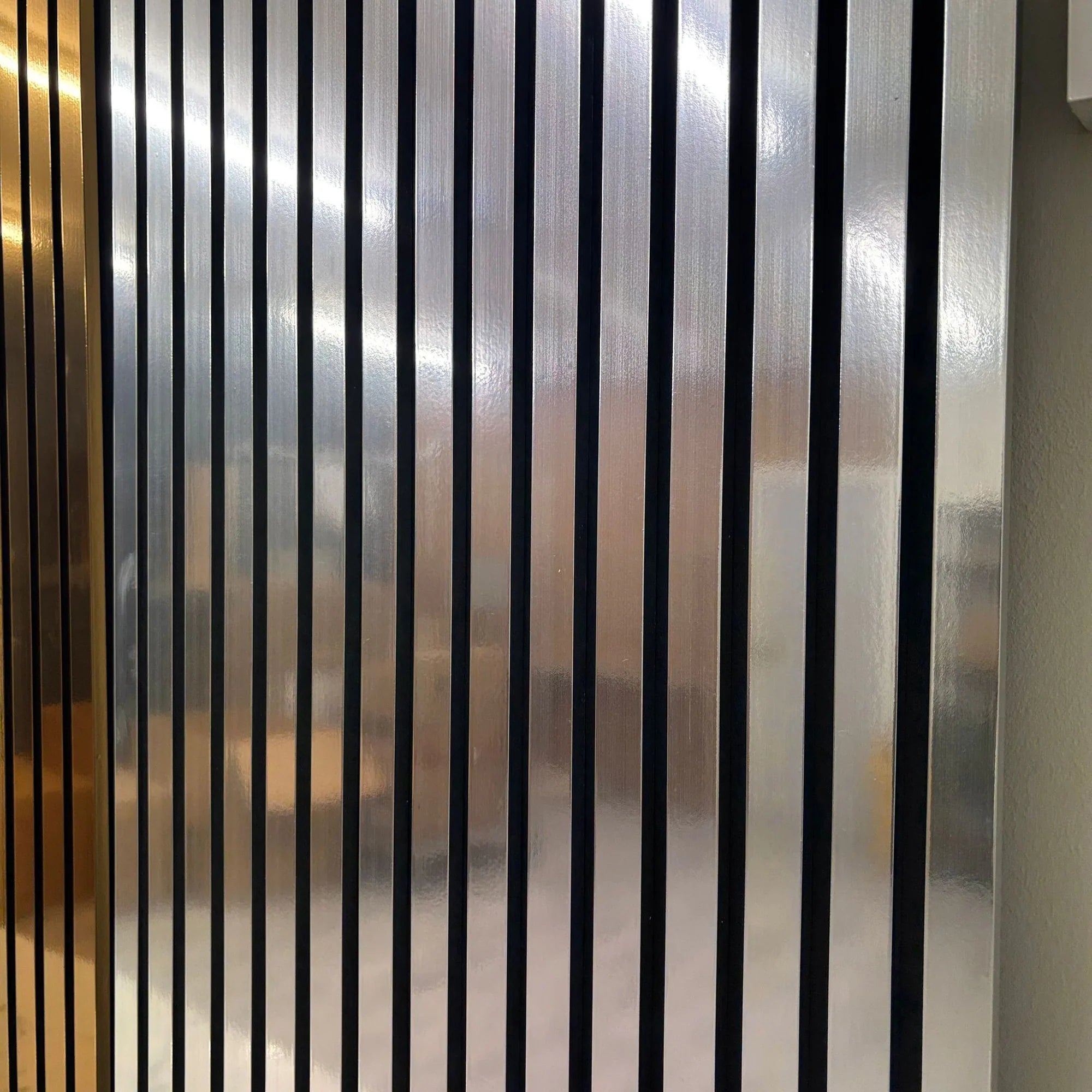 Close-up of 60x240cm Chrome Metallic Acoustic Wall Panel by Solid Furniture LTD showing reflective surface and slat detail