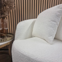 Side view of Cuddle Accent Chair highlighting curved swooping arms and plush bouclé upholstery. solid furniture UK