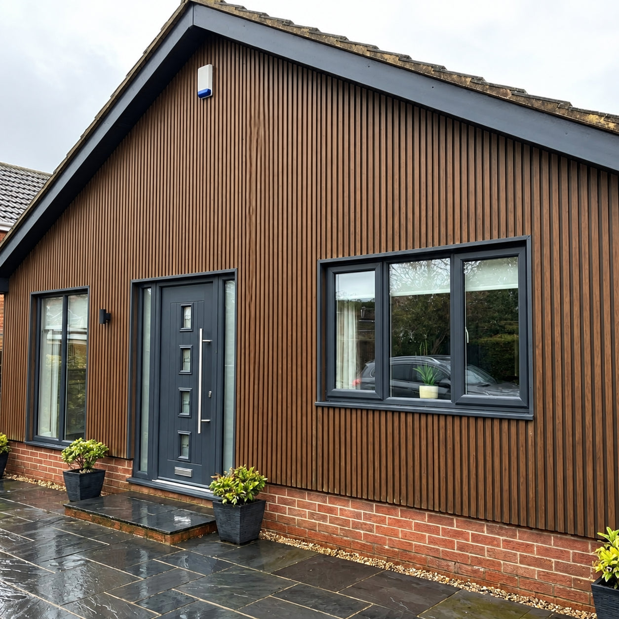 Dark oak waterproof slatted WPC wall panels 15x240cm on house exterior – Solid Furniture UK