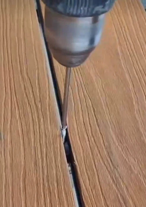Close view of decking fittings being fixed with screws during outdoor decking installation on subframe structure. solid furniture UK
