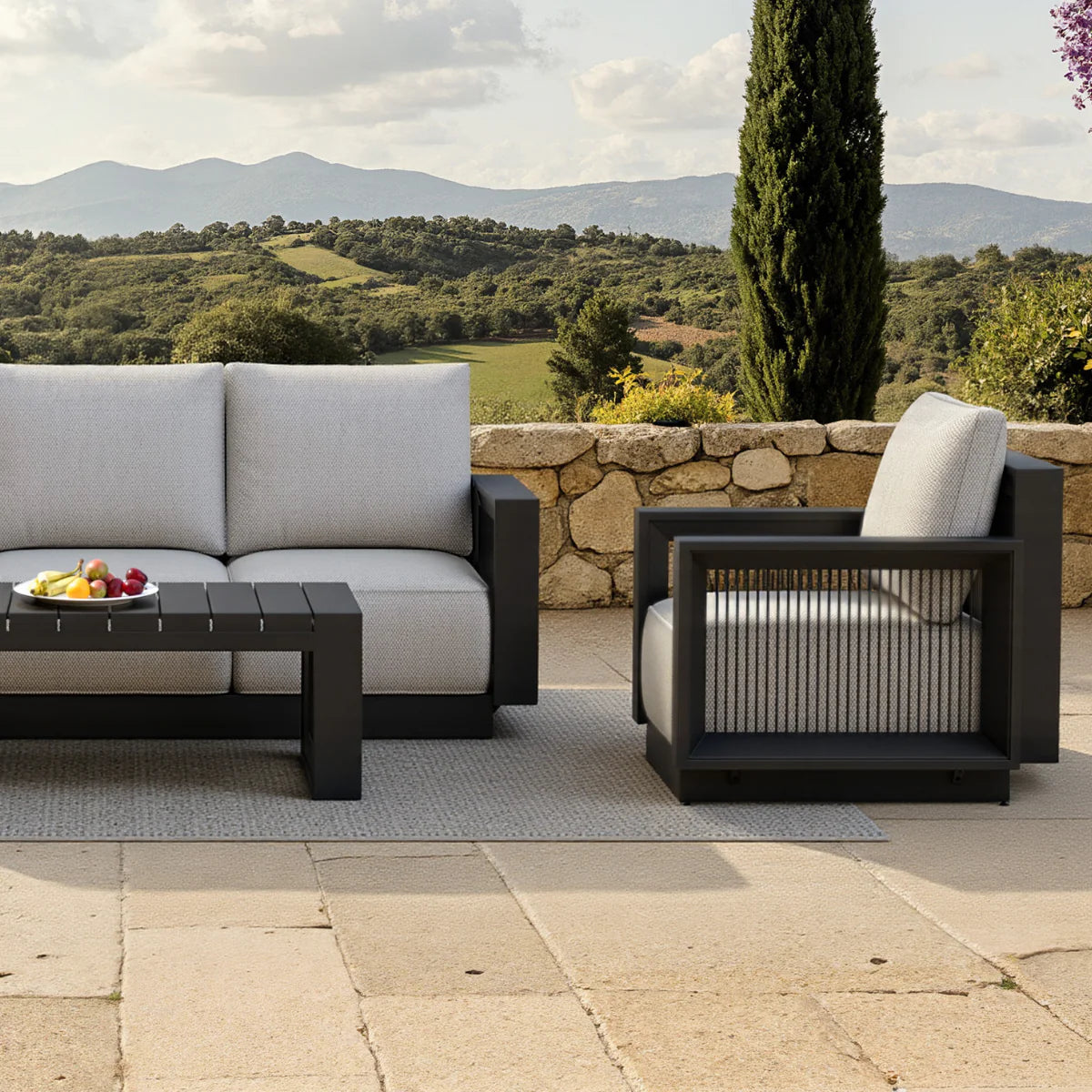 Ikos Onyx 5 seater outdoor lounge set side view showing sofa and chairs, modern aluminium garden furniture with cushioned seating solid furniture UK