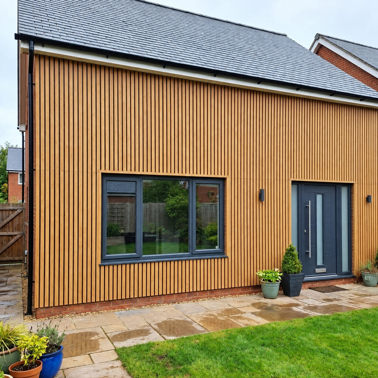Light Oak WPC wall panels installed on the exterior of a house, slatted wood effect finish, 15×240cm, 12mm thick, Solid Furniture UK