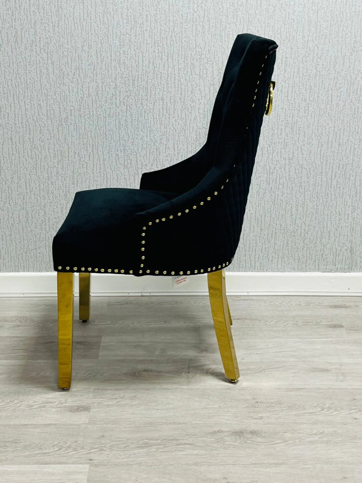 Side view of Majestic Black Gold dining chair with padded seat and decorative gold ring knocker from Solid Furniture UK