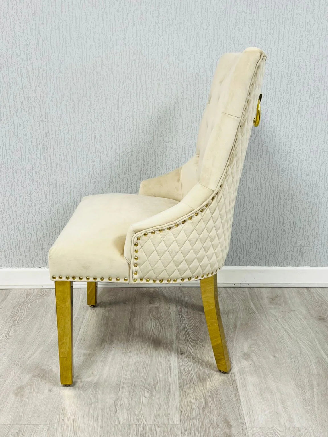 Side view of Majestic Mink Gold dining chair with padded seat and gold ring knocker detail from Solid Furniture UK