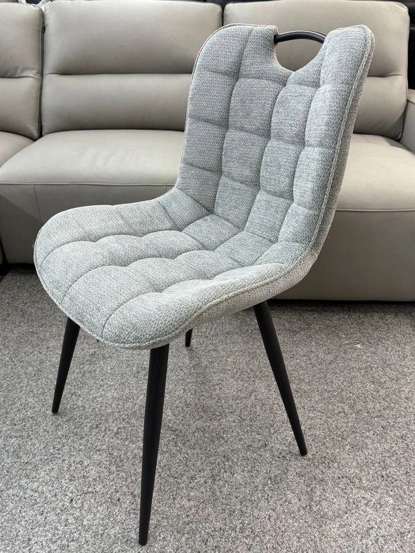 Side view of grey Monza fabric dining chair showing sleek frame and padded seat design