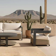 Side view of Selene wicker outdoor garden lounge set featuring 3-seater sofa and armchairs with grey aluminium frame and deep cushions, set in a garden with scenic mountain view in the background solid furniture UK