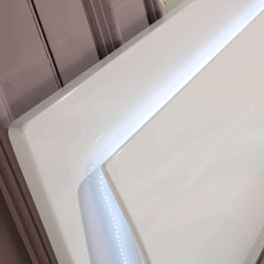 Solid Furniture UK Slim LED high gloss white ottoman storage bed frame shown from a side angle with illuminated LED headboard