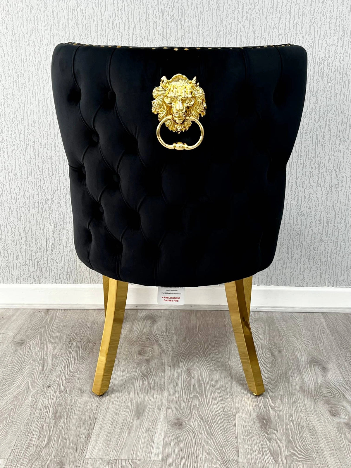 Back side view of Valentino black velvet dining chair featuring lion head knocker detail, gold-finished legs and luxury upholstered design by solid furniture uk