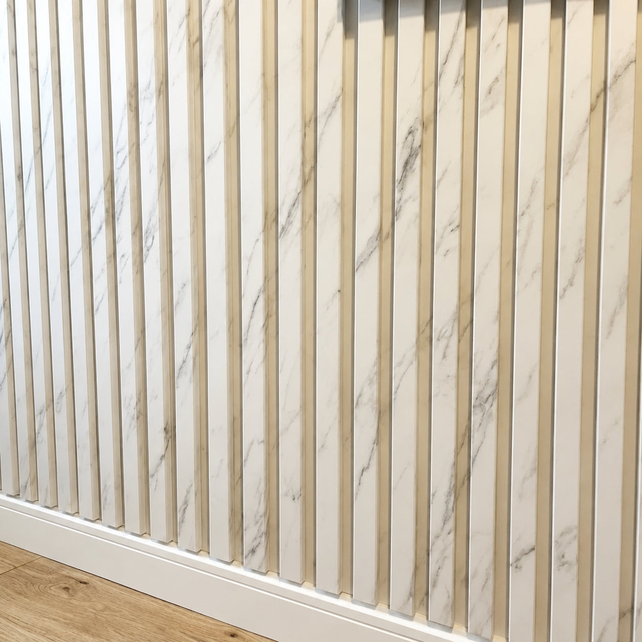 White and grey marble effect waterproof slatted wall panels 15x240cm installed on an interior wall by Solid Furniture UK