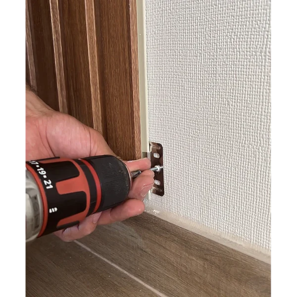 Using a drill machine to fix WPC wall panel brackets from Solid Furniture UK quickly and securely during wall panel installation process