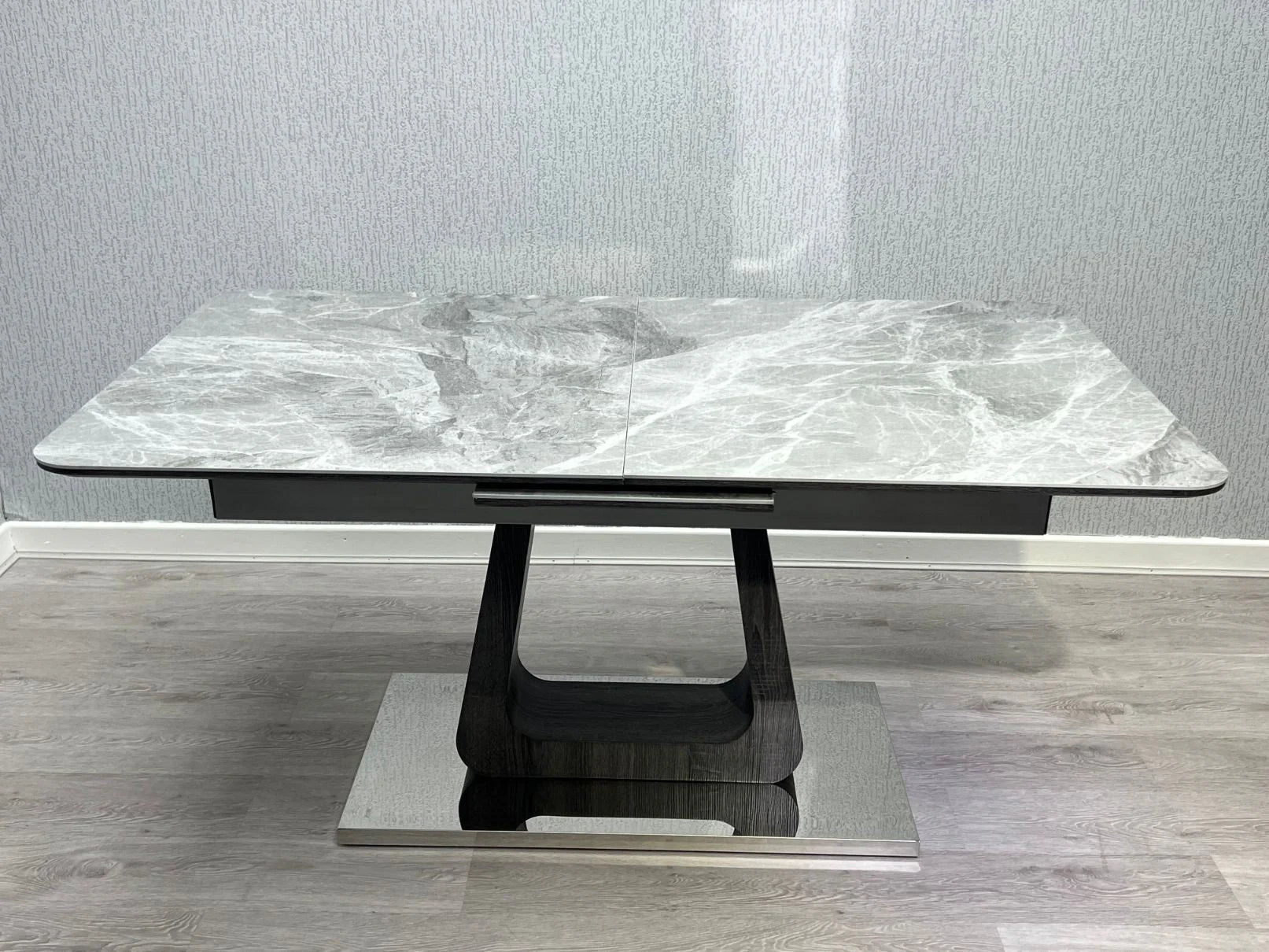 Man using Zermatt extendable dining table grey ceramic marble effect in modern UK dining room showing real lifestyle setting from Solid Furniture UK
