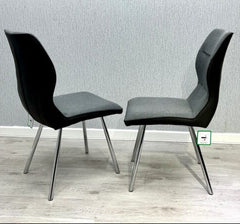 Pair of Zermatt grey dining chairs side view showing upholstered design and chrome legs from Solid Furniture UK